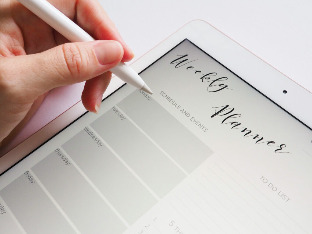 A woman using her digital planner on an Ipad to set up her day