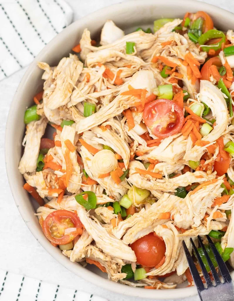 A bowl of bon bon chicken. A nix of leftover chicken, veggies and a tangy dressing sauce for the perfect dinner recipe for the lazy summer nights 