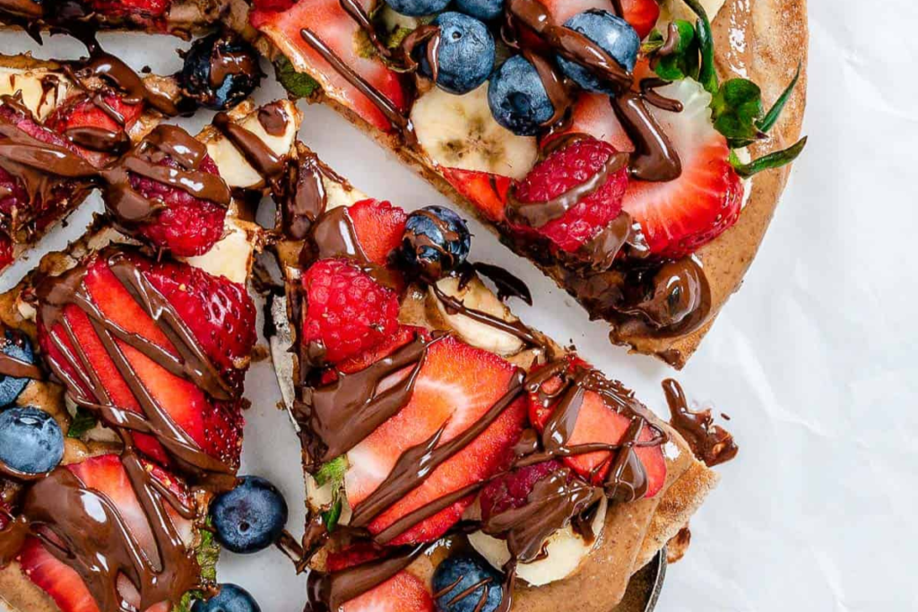 a creative summer pizza topped with beeries and chocolate. A dessert to bring to a bbq desserts