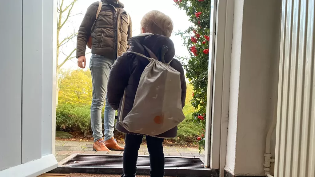 A toddler with a backpach about to get out to join his dad. Carry-on essentials when traveling with toddlers